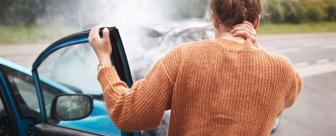 Woman holding the back of her neck after a car wreck