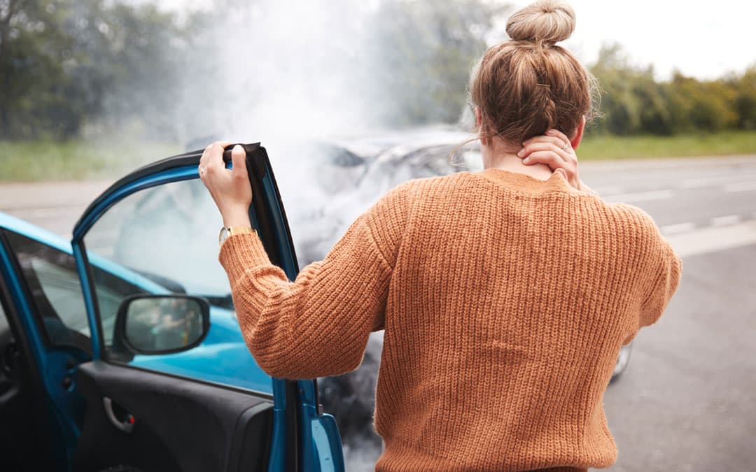 Woman holding the back of her neck after a car wreck